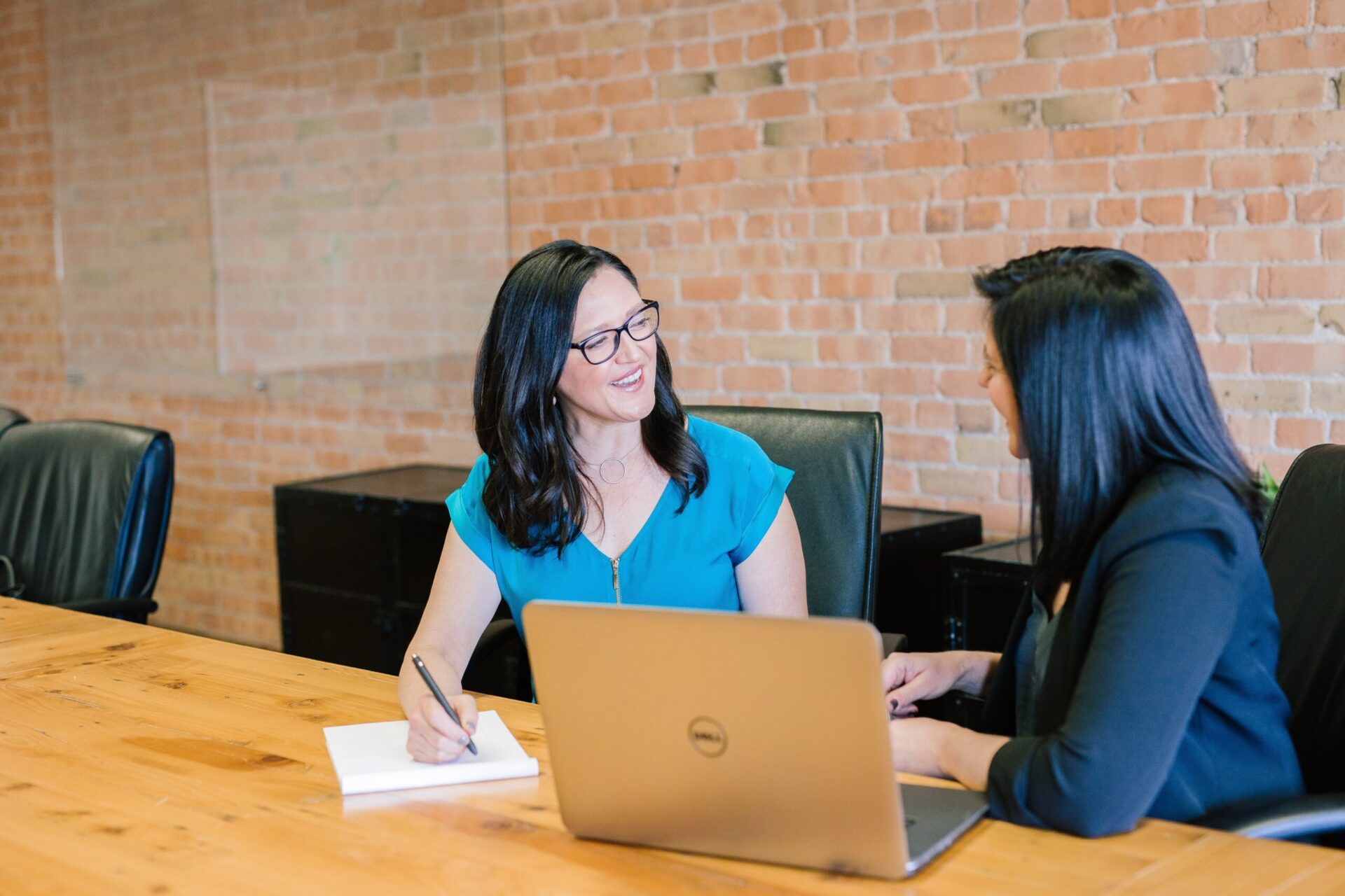 Two women talking in a office setting.