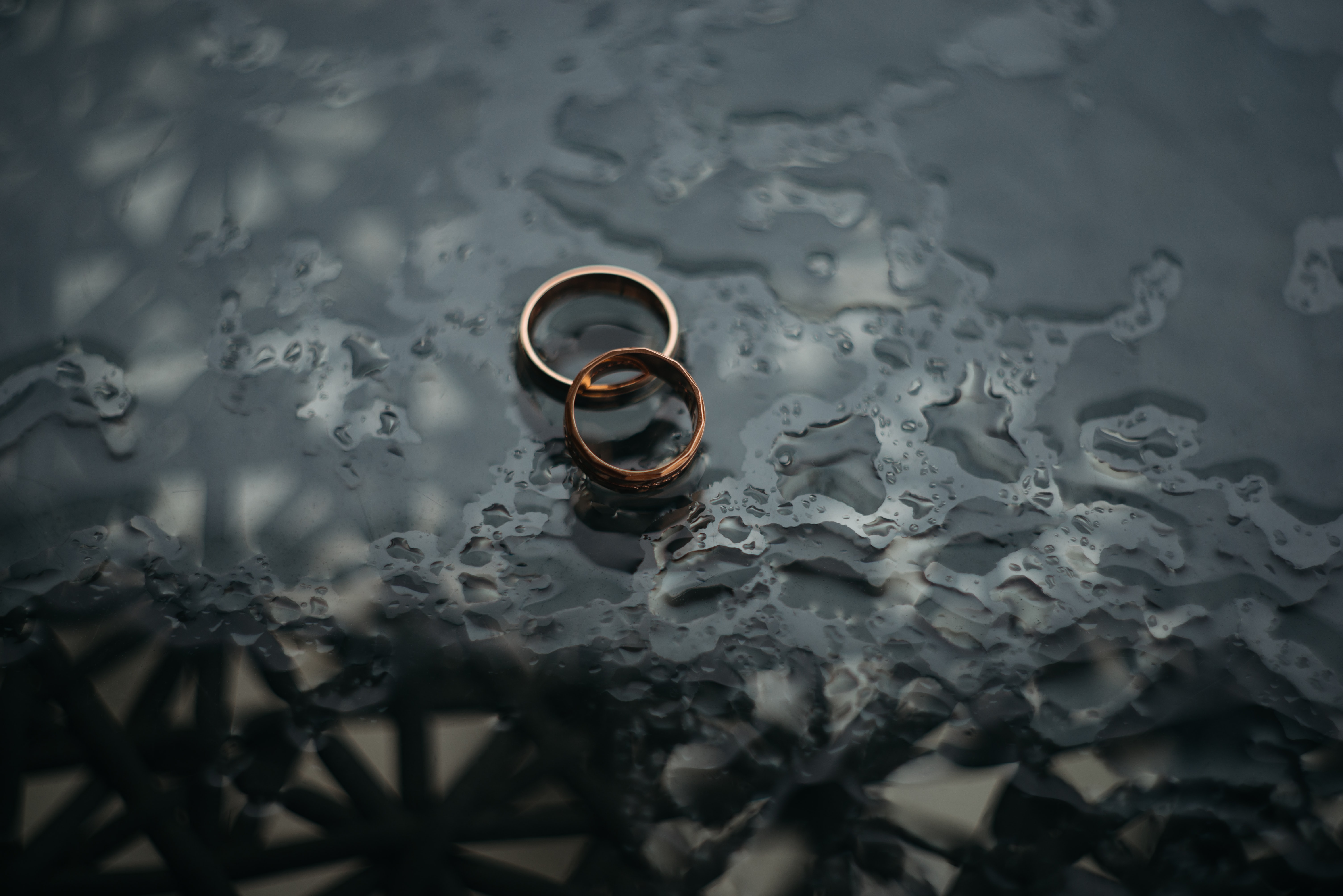 Two rings laying over each other on a wet surface.